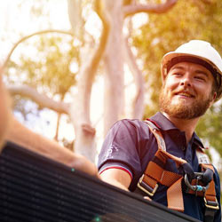 Solar installer on roof and smiling