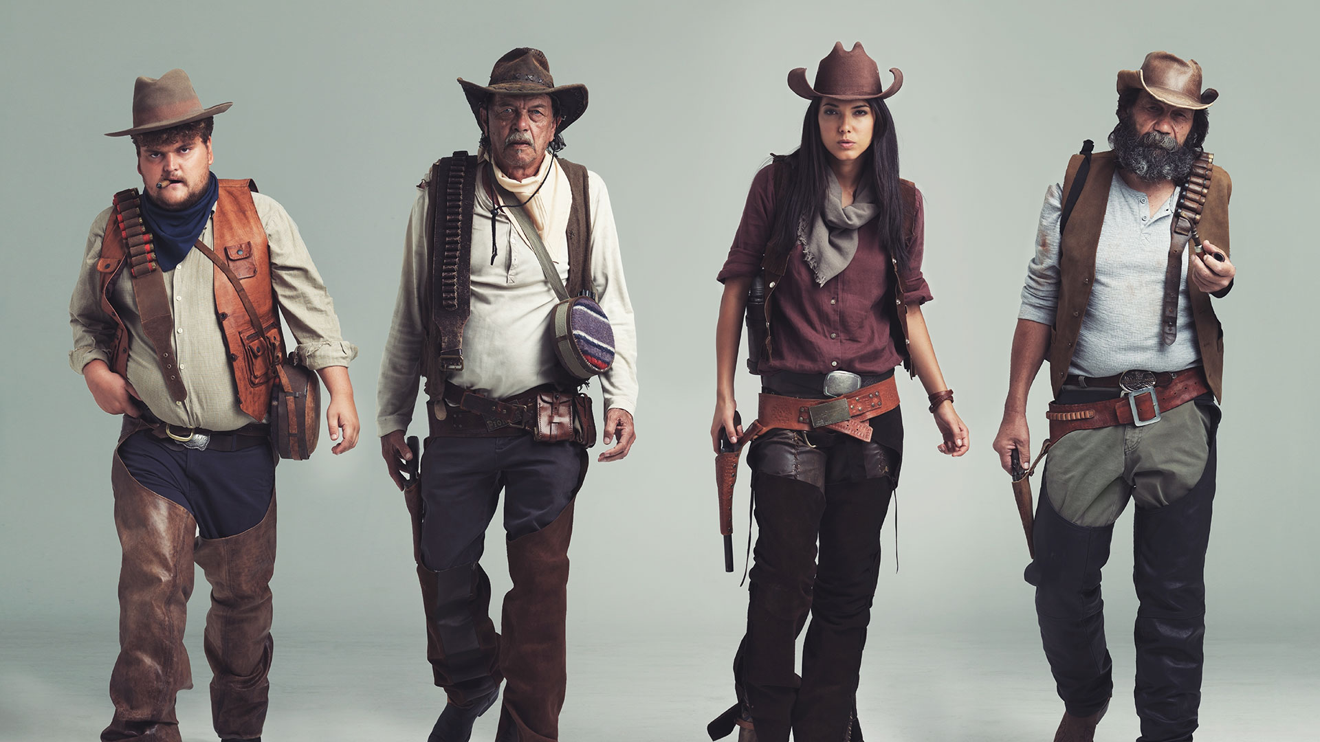 3 men and one woman dressed as cowboys